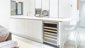 A modern kitchen with a central island, stainless steel appliances, and pendant lighting.