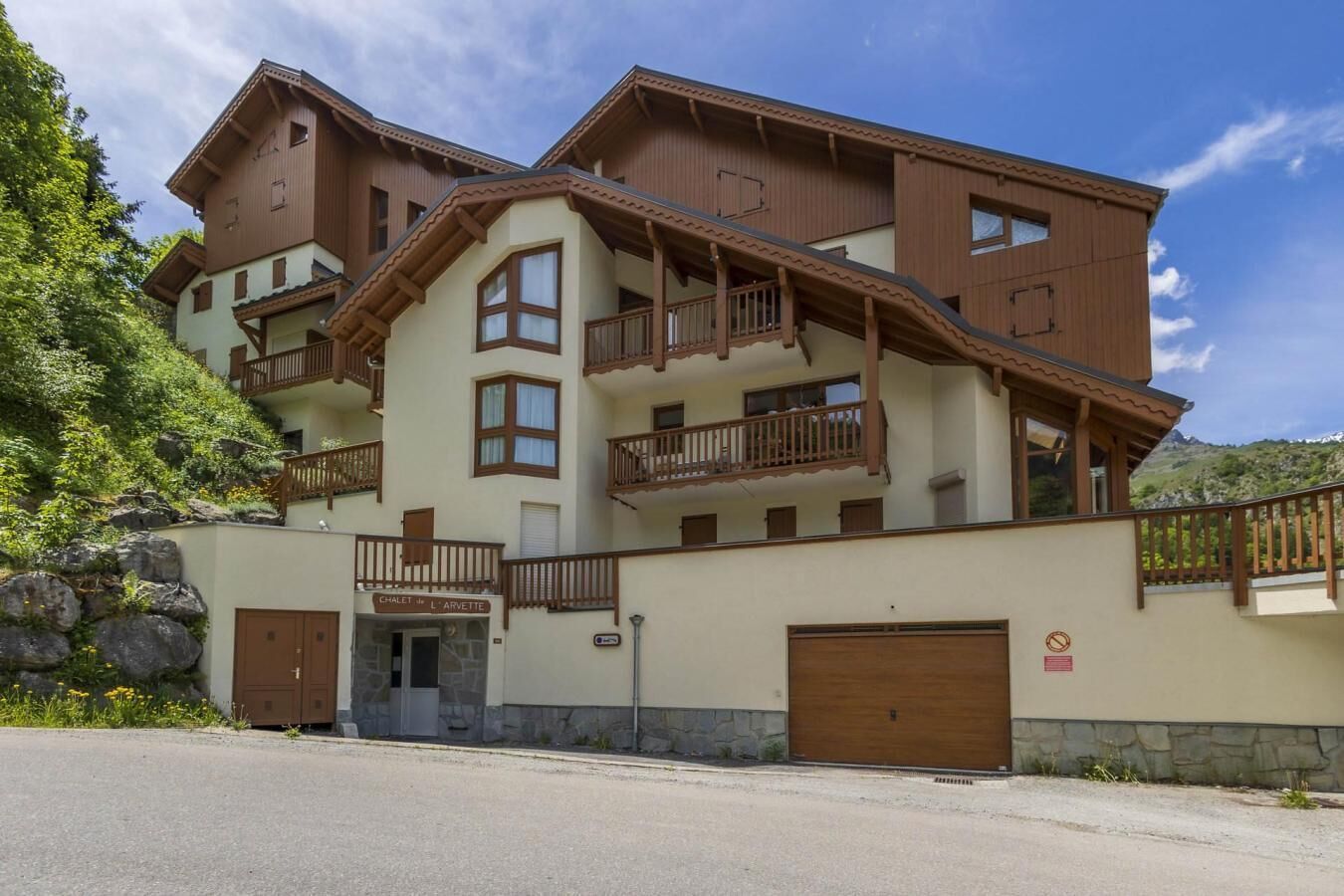 Un hotel de varios pisos con balcones, fachada de piedra y un letrero que indica una cabaña.