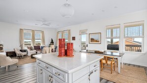 A spacious living area with a large white island, a dining table with chairs, and a kitchen area with a white countertop. - Cold Pass Cottage - 3BR, panoramic views (Freeport)