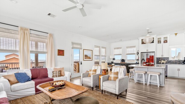A spacious living area with a sofa, armchairs, a coffee table, and a kitchen area with bar stools. - Cold Pass Cottage - 3BR, panoramic views (Freeport)