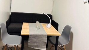 A small, compact room with a sofa, two chairs, a table, and a lamp. - Stunning 1-bed Studio (Prague)