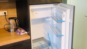 A modern kitchen with a built-in refrigerator, a coffee maker, and a bag of tissues on the counter. - Stunning 1-bed Studio (Prague)
