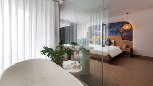 A modern bedroom with a large bed, a glass shower enclosure, and a large window with sheer curtains. - Tropical Paradise Sapa Hotel (Sa Pa)