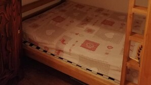 A bunk bed with a wooden frame and a patterned mattress. - 50m from ski lifts, 1st floor, terrace, parking, tv, 30m², Arêches-Beaufort (Beaufort)