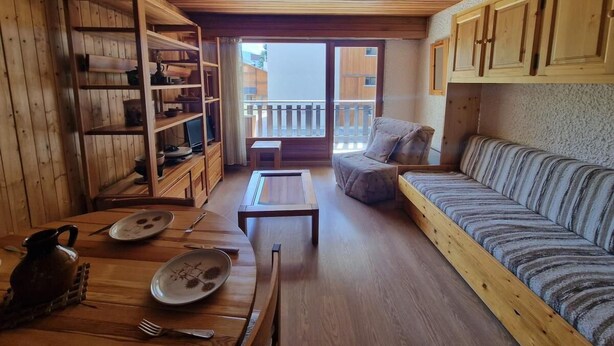 Un intérieur en bois avec un canapé, une table et une bibliothèque.
