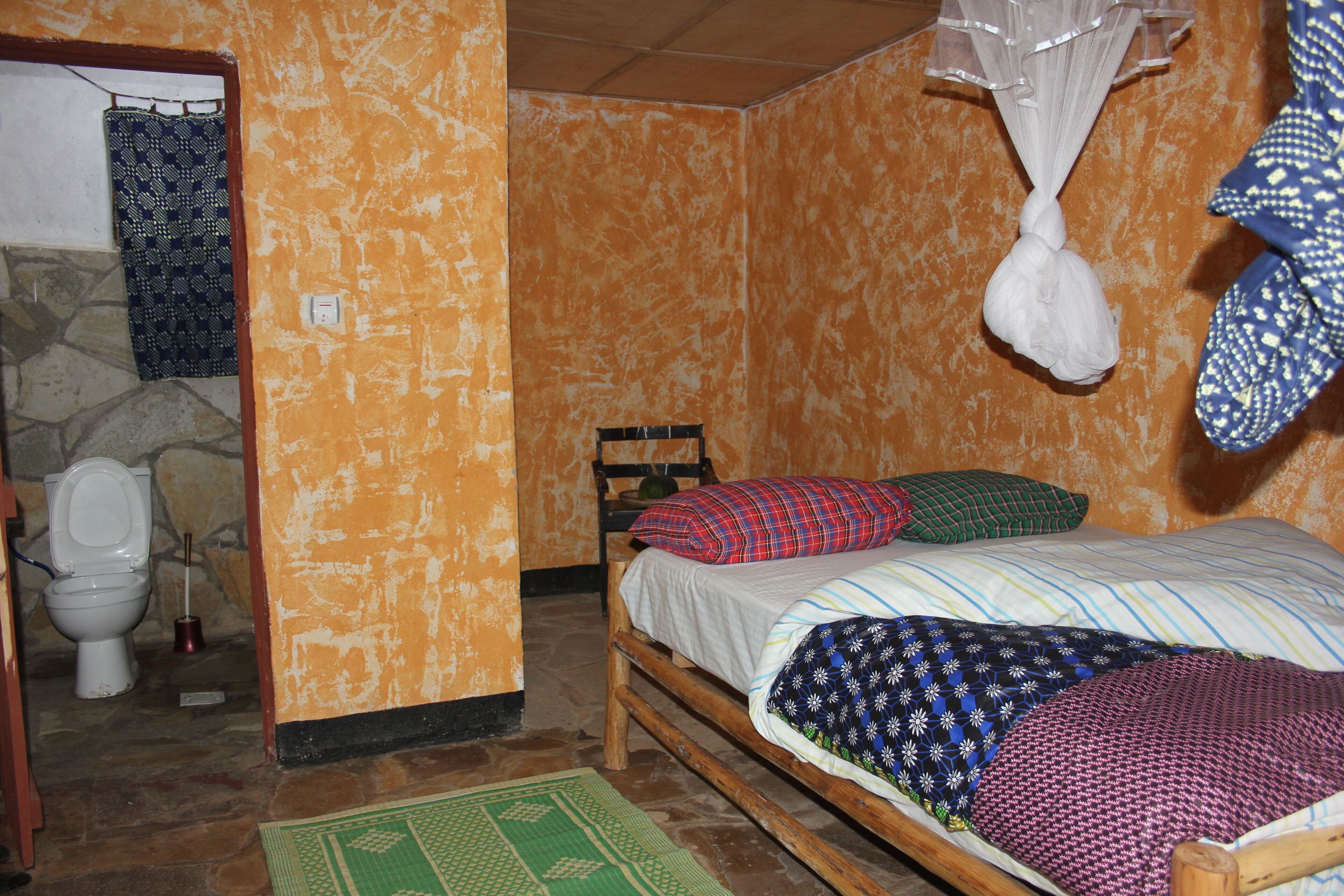 Quarto pequeno e compacto com uma cama de solteiro, cabeceira de madeira e design simples e funcional.