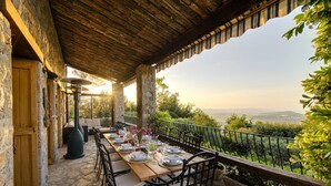 An outdoor dining area with stone walls, a wooden table set for four, and a view of the countryside. - Vue Féérique, le Calme de la Campagne (Le Tignet)