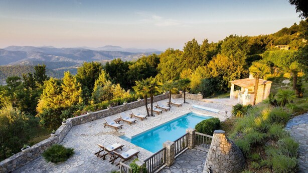 A pool area with stone flooring, lounge chairs, and a view of the surrounding landscape. - Vue Féérique, le Calme de la Campagne (Le Tignet)
