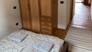 A bedroom with a bed, a wardrobe, and a view of an outdoor balcony. - 1 Bed Flat - Sleeps 2 - Pets - Smoking on Terrace (Prague)