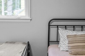 A bedroom with a bed, a window, and a radiator. - Charming 5B Home in Neighborhood (South Burlington)