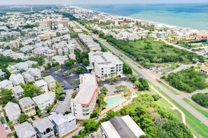 An aerial view of a coastal residential area with multiple buildings, roads, and a beach. - 1 br condo on 30a. New remodeled & furnishings. Walking distance to everything! (Panama City Beach)