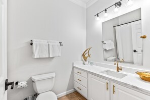 A modern bathroom with a white sink, gold fixtures, and a large mirror. - 1 br condo on 30a. New remodeled & furnishings. Walking distance to everything! (Panama City Beach)