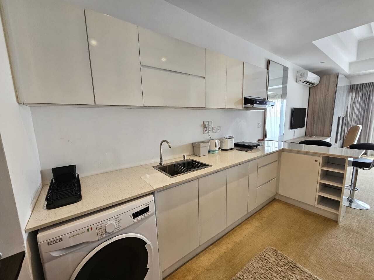 A modern kitchen with white cabinets, a built-in dishwasher, and a sink.