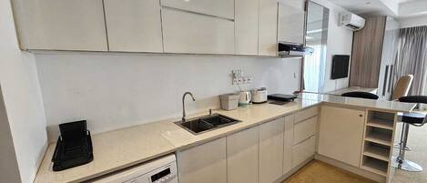A modern kitchen with white cabinets, a built-in dishwasher, and a sink.
