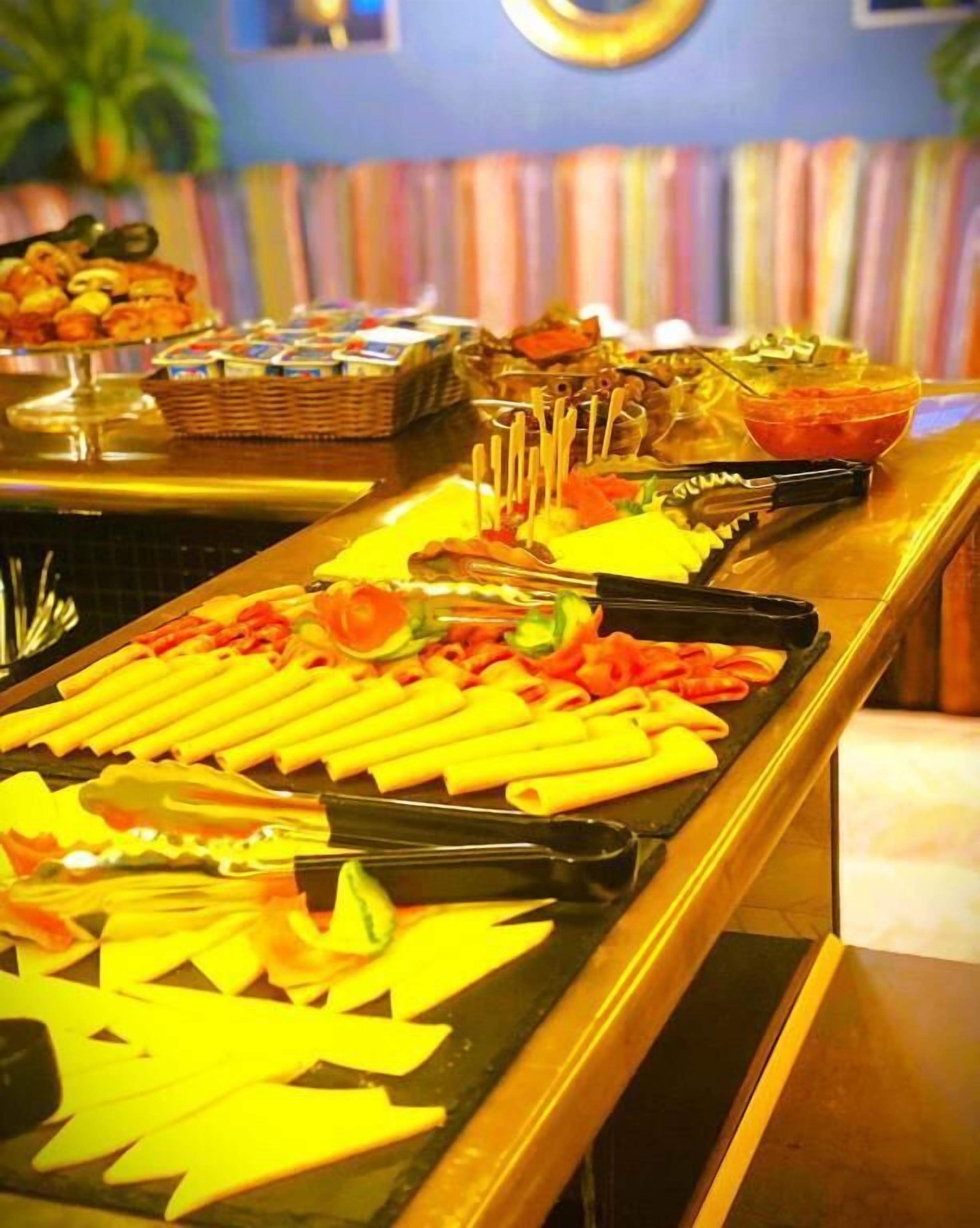 Un bufé con diferentes opciones de comida y utensilios.