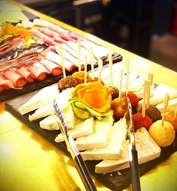 A buffet with various food items including meats, cheeses, and vegetables. - Torres Poiana (Brasov)