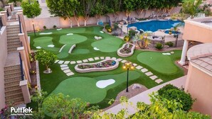 A golf course with a swimming pool and a landscaped garden. - Modern Lake Escape: Pool, Spa, Dock, Game Room, Mini Golf, Sleeps 29! (Lake Ozark)