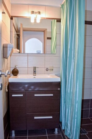 A bathroom with a sink, mirror, and a telephone. - Ostria's House (Kefalonia)