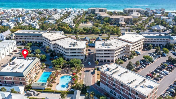 An aerial view of a coastal hotel complex with multiple buildings, a swimming pool, and a view of the ocean. - This adorable studio in The Villages of South Walton is tastefully decorated! (Seacrest)