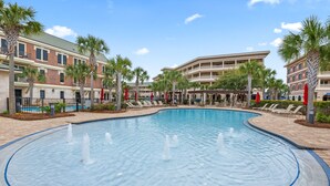 A swimming pool with water fountains, surrounded by palm trees and lounge chairs. - This adorable studio in The Villages of South Walton is tastefully decorated! (Seacrest)