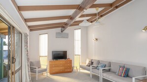 Un salon moderne avec un canapé, un téléviseur et un meuble en bois.