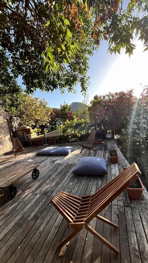 A wooden deck with lounge chairs, cushions, and a small table. - Palmira Selimiye (Marmaris)