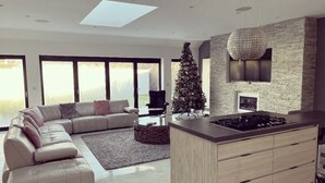 A modern living room with a sectional sofa, a coffee table, and a fireplace.