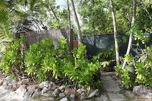 Stroll through the lush garden, surrounded by a winding stone pathway and a wooden fence.