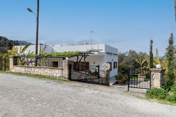 A white villa with a stone wall entrance, a metal gate, and a sign reading "Villa Klapas". - Klapas – Vacation villa in Crete, Greece (Chania)