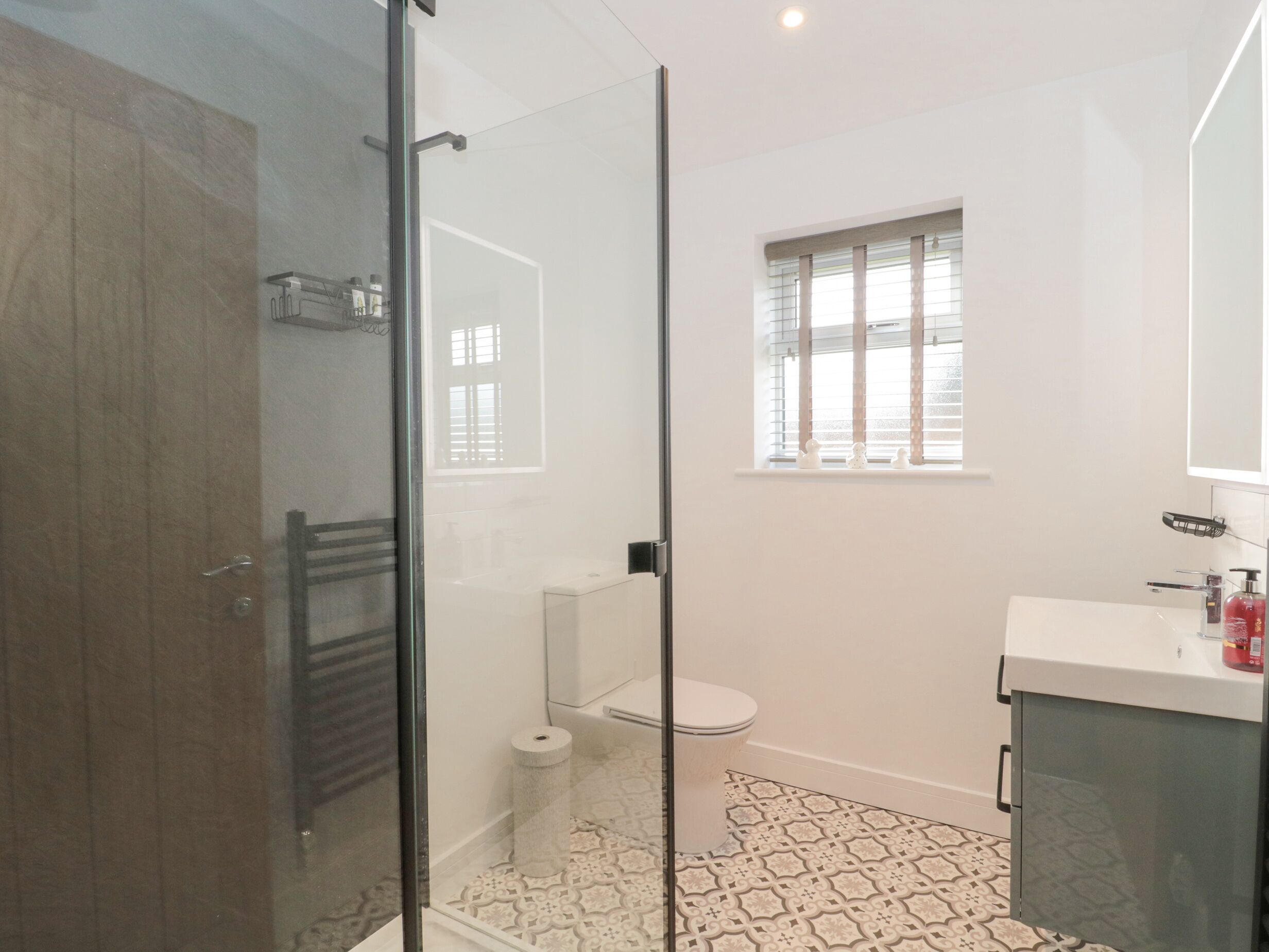 Une salle de bain moderne avec une douche à parois de verre, des toilettes et un lavabo avec un miroir.