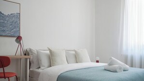 A neatly arranged hotel room with a bed, a desk, and a chair. - Apartment for 9 people - 4 min walk from Mestre Station (Venice) (Venezia)