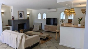 Una sala moderna con chimenea, televisor y comedor con barra.