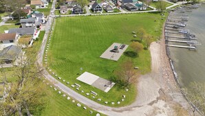 En vy över en park från ovan, med en lekplats, ett stort öppet grönområde och en brygga med båtar.