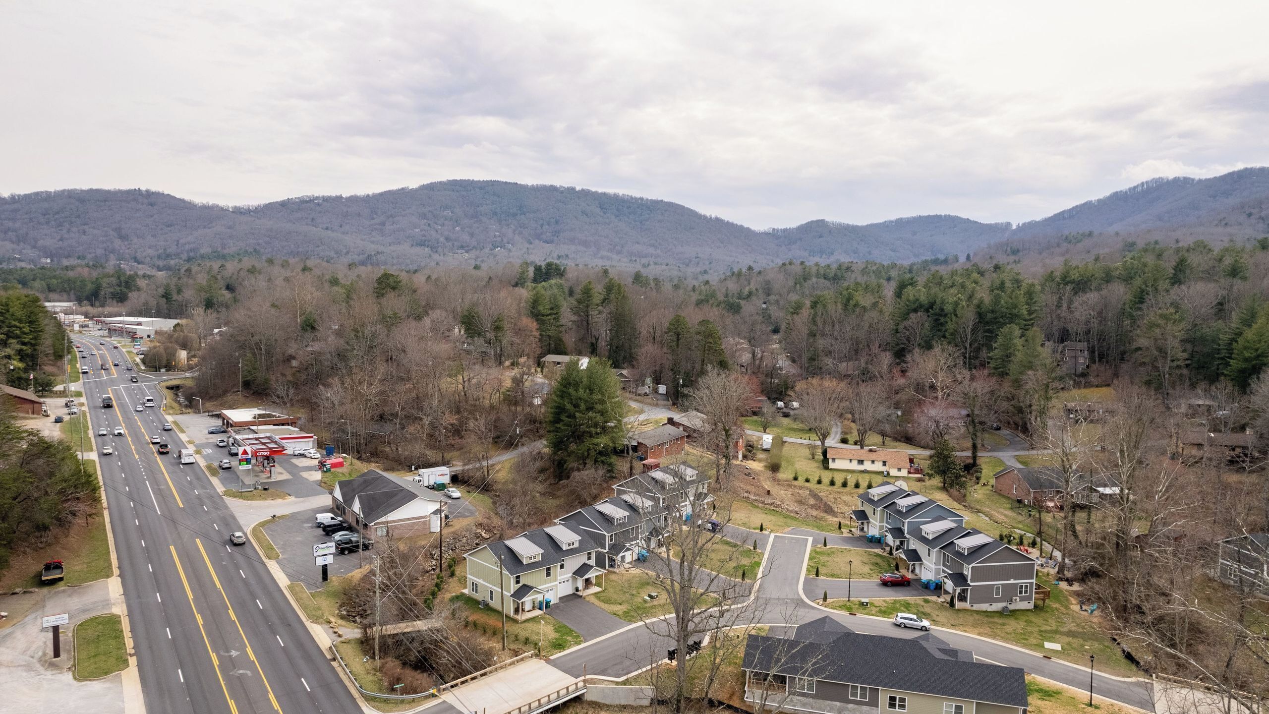 A suburban area with a main road, residential houses, and a gas station.