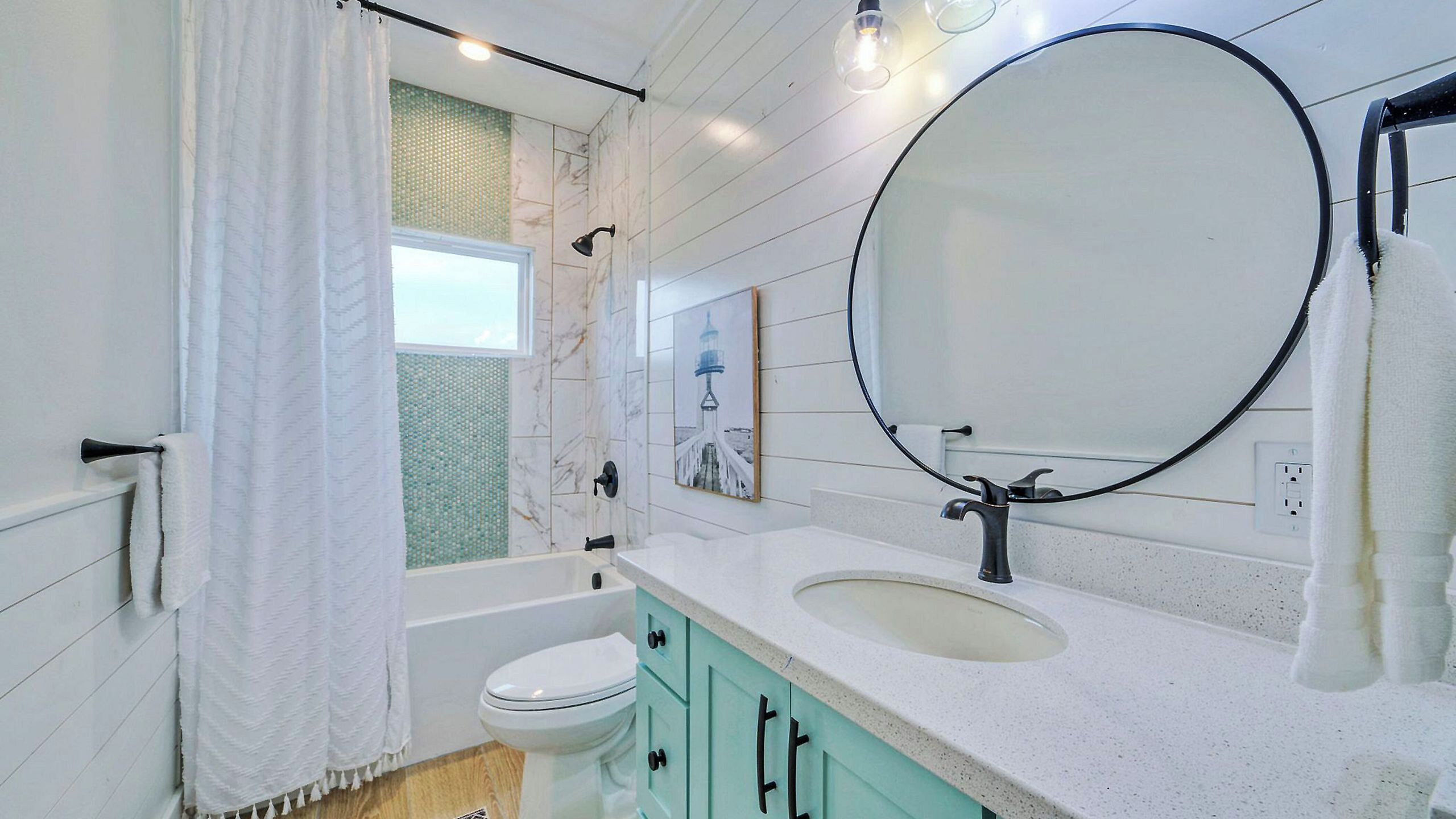 Une salle de bain avec une baignoire, des toilettes, un lavabo et un grand miroir.