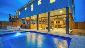 En swimmingpool med liggestole og en overdækket patio.