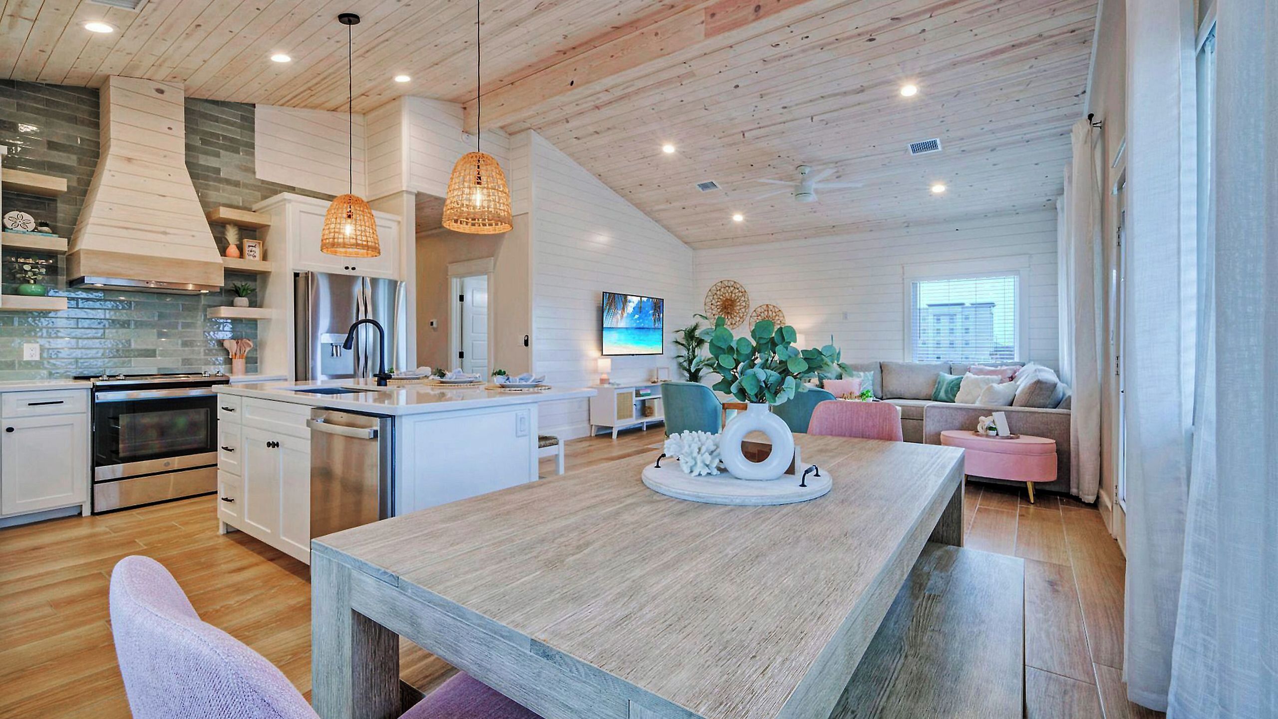 A modern kitchen with white cabinetry, a central island, and pendant lighting.
