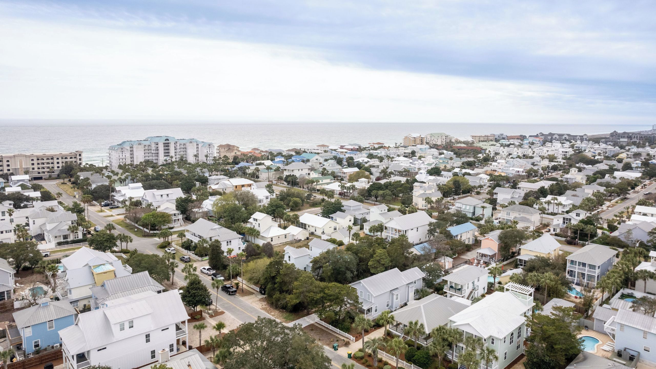 A coastal residential area with houses, a beach, and a marina.