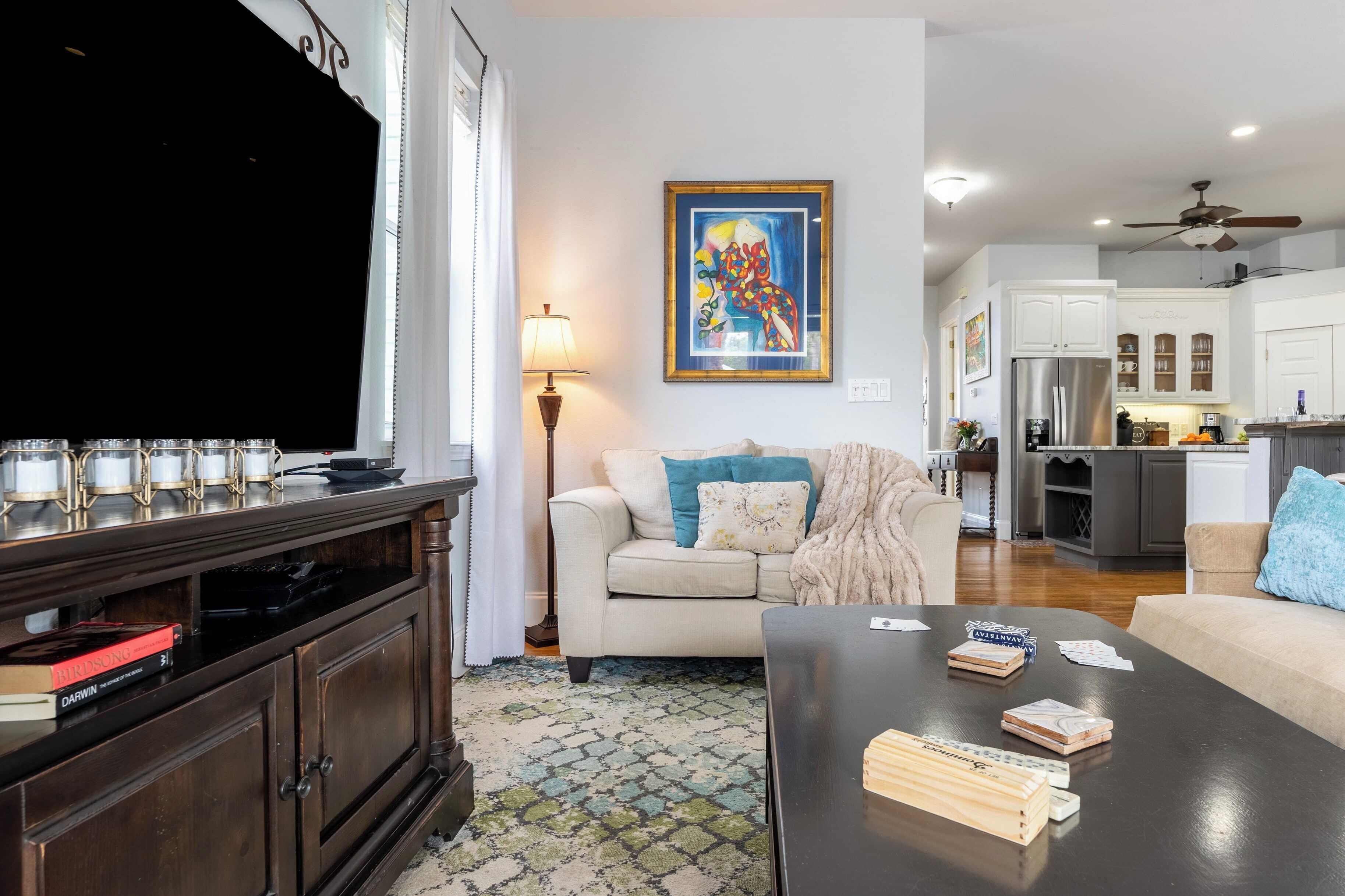 A living room with a TV, a sofa, a coffee table, and a bookshelf.