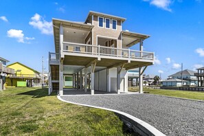 Une maison à deux étages avec un balcon, une véranda et une allée.