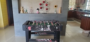 Enjoy a game of foosball in this cozy space, featuring a kitchen area and decorative touches.