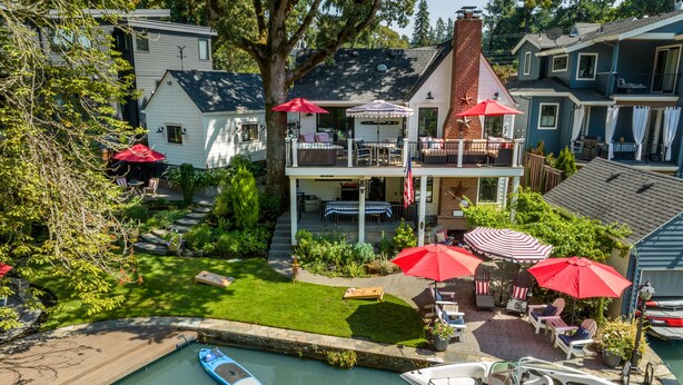 A two-story house with a covered patio, a boat dock, and a small pool.
