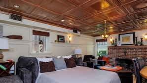 A well-furnished room with a large bed, a fireplace, and a cozy seating area.
