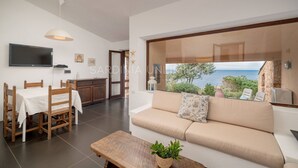 A modern living room with a sofa, a dining table, and a TV.