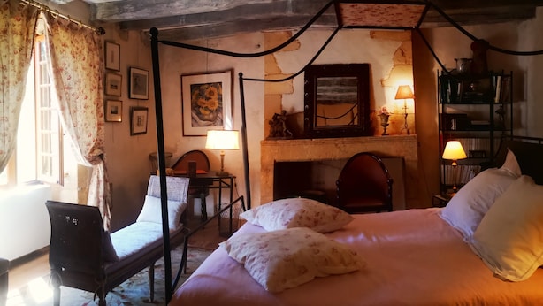 Une chambre à coucher de style traditionnel, avec un lit à baldaquin, une cheminée et une bibliothèque.