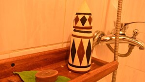 A bathroom with a wooden shelf holding a soap bar and a decorative container. - Room in B&B - Amahoro Guest House Triple Room With Shared Bathroom (Muhoza)