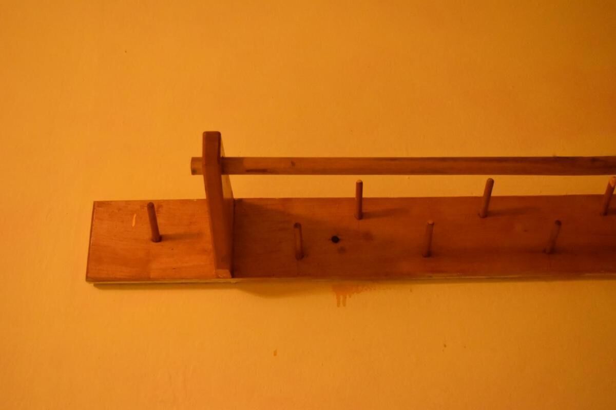 Un porte-manteau en bois, fixé au mur, avec des crochets.