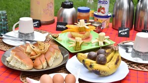 Un menjador de pícnic amb pa, ous, bananes i una beguda etiquetada com 'tea africana'.