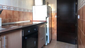 A kitchen with a microwave, oven, and refrigerator.