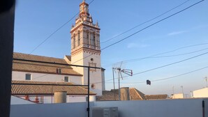 A building with a prominent tower and a flat-roofed structure in the foreground.